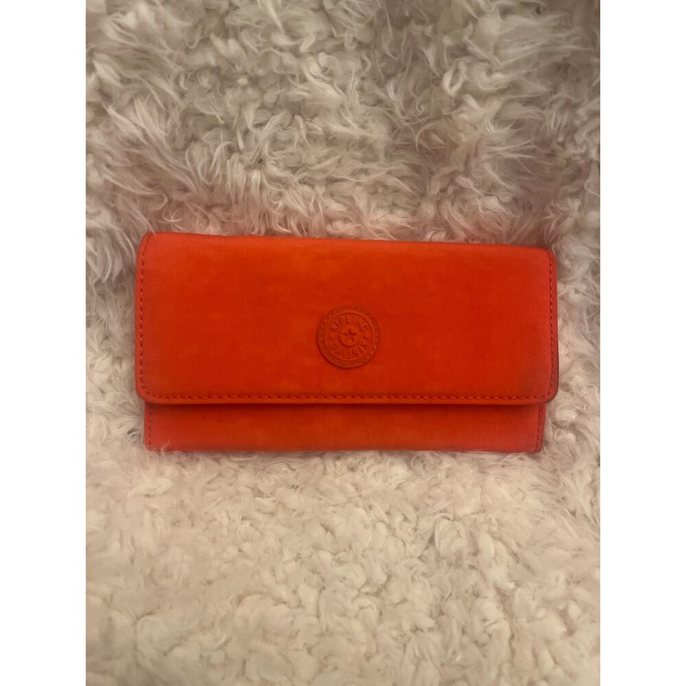 Kipling Money Land snap wallet in an orange nylon material.